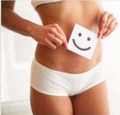 woman with a smily face cutout in front of her stomach