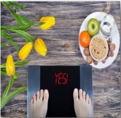 weight management with a scale and a healthy meal