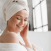 Calm serene young woman in bathrobe and towel relaxing after taking bath