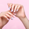 Beautiful pink and blue manicure with crystals on female hand. Close-up. Picture taken in the studio