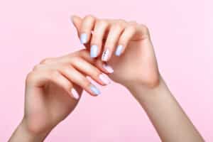 Beautiful pink and blue manicure with crystals on female hand. Close-up. Picture taken in the studio