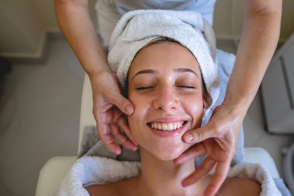 Beautiful cheerful woman enjoying her visit to beautician undergoing a chemical peel.