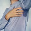 Man with hyperhidrosis sweating very badly under armpit in blue shirt. wet spot on my shirt