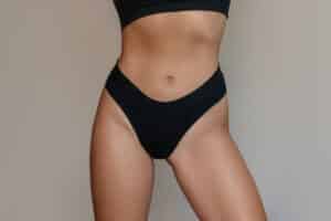 Close-up of a woman’s midsection and bikini area, representing professional body waxing and hair removal.