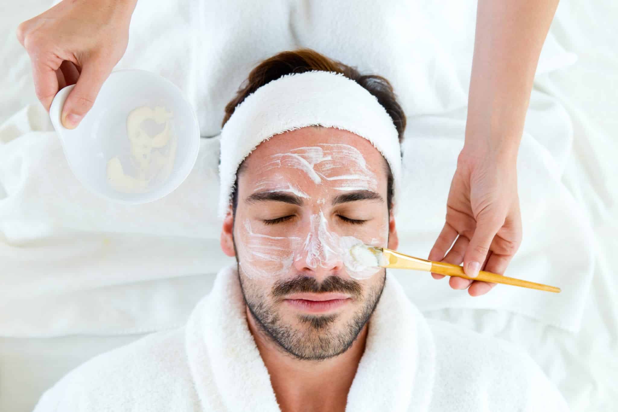 Man With Clay Facial Mask In Beauty Spa Cosmetic Skin Care