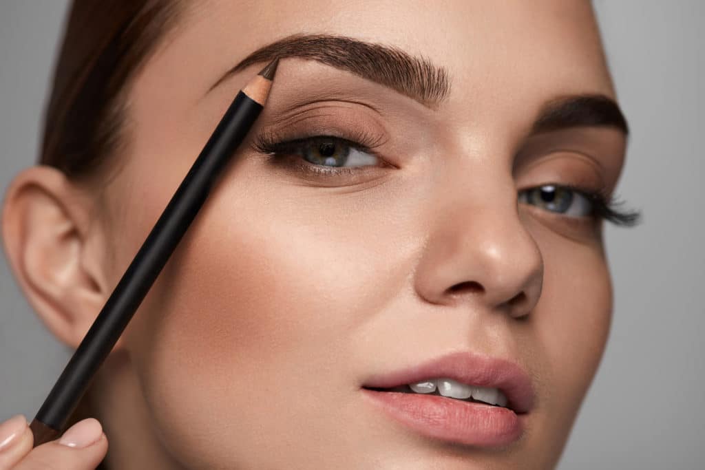 Eyebrows Shaping. Portrait Of Sexy Young Girl With Brow Pencil. Closeup Of Beautiful Glamourous Woman With Professional Makeup Contouring Brows With Eyebrow Pencil. Beauty Concept. High Resolution