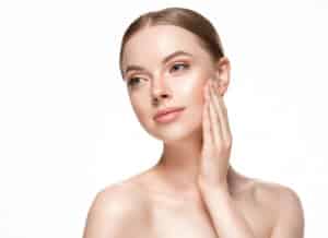 Woman touches her own healthy skin after oxygen therapy.