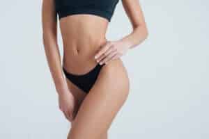 Woman in black workout attire enjoys her smooth skin following stretch mark treatments