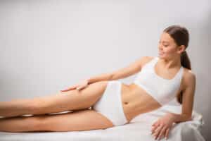 Woman rubs her smooth legs happy to be rid of cellulite.